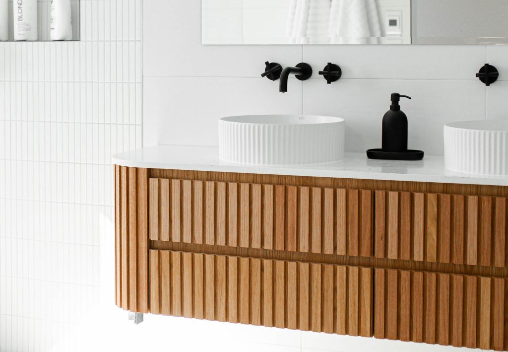 Modern bathroom with flutted woodern panels and black finishes