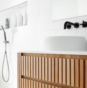 Modern bathroom with flutted woodern panels and black finishes