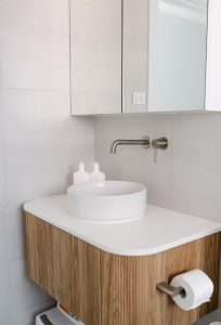 simple bathroom with wooden flutted vanity